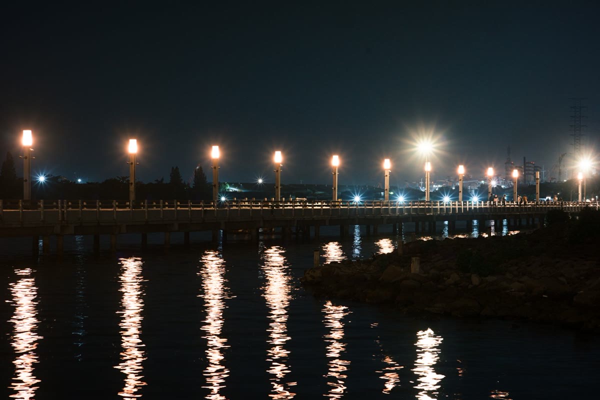 常夜灯が海面に映る夜の堤防